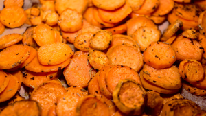 A pile of bright orange, thinly sliced roasted sweet potatoes.